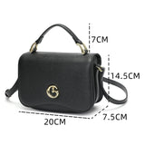 Small black women's handbag with top handle and shoulder strap