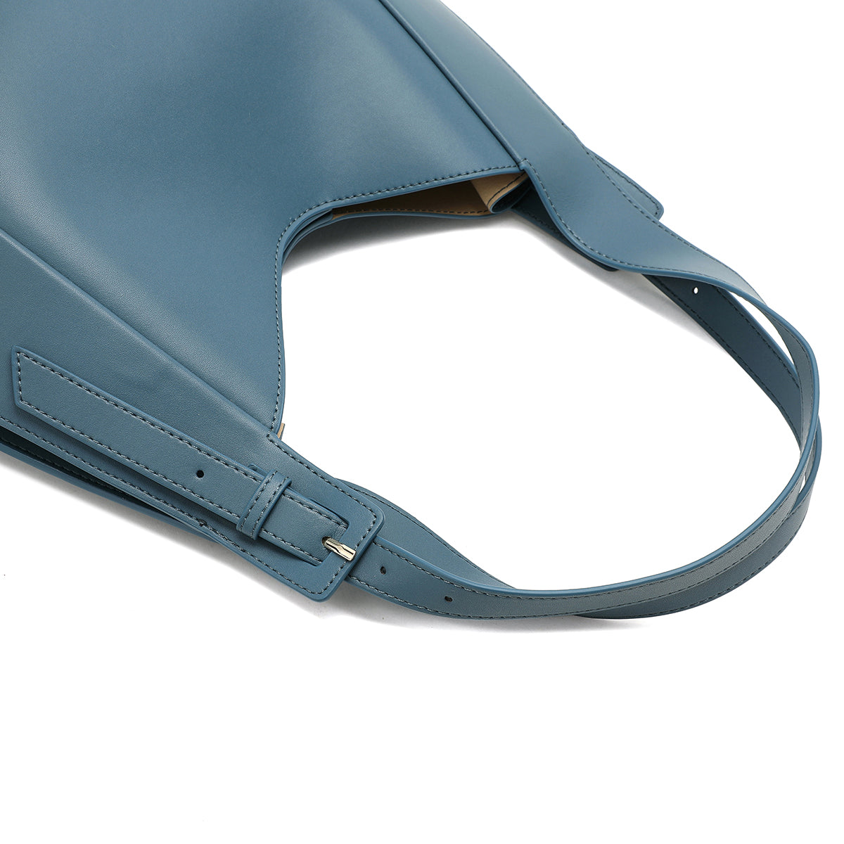 تفاصيل حزام قابل للتعديل على شنطة يد نسائية من الجلد باللون الأزرق الفاتح.